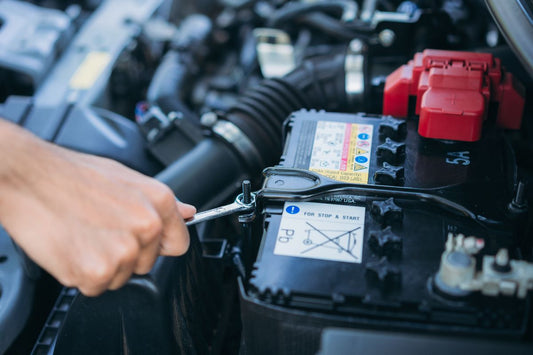 A technician inspects a car battery