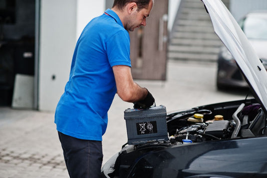 A technician replacing a car battery