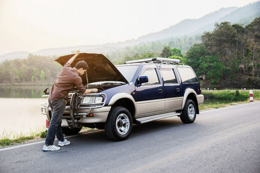 A man checking on his broken down car